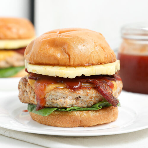 BBQ Hawaiian chicken burger with bacon, pineapple, cheese, lettuce, and barbecue sauce on a toasted bun