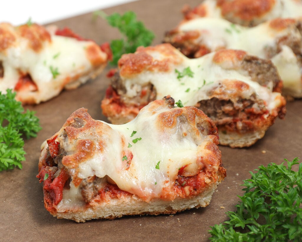Meatball French bread pizza with melted mozzarella, homemade sauce, and fresh parsley on toasted French bread