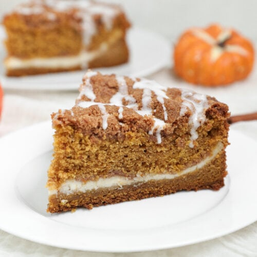 Pumpkin Coffee Cake with Cream Cheese is the perfect fall breakfast or dessert made with moist pumpkin cake, a rich cream cheese filling, buttery cinnamon pecan streusel, and a simple vanilla glaze.