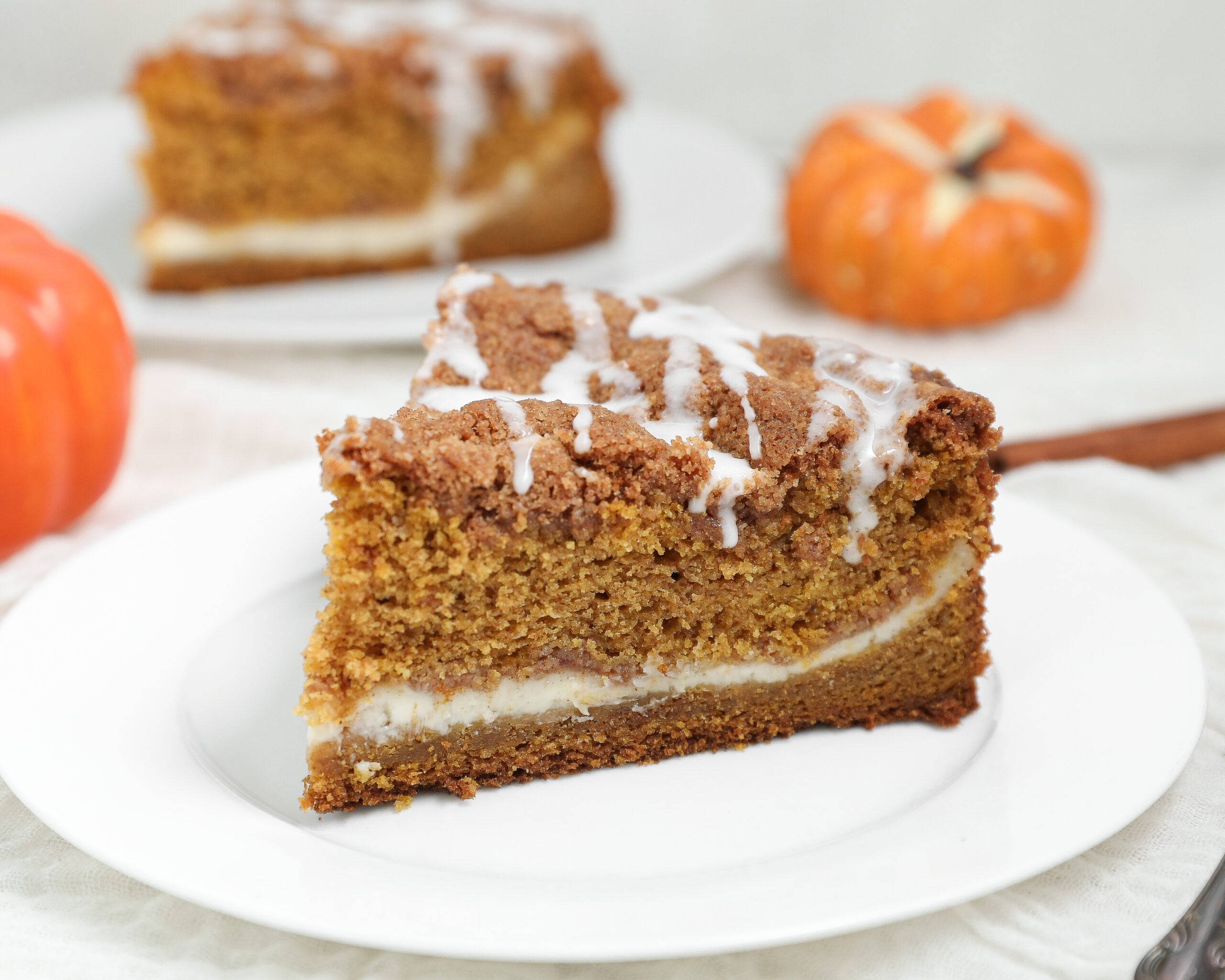 Pumpkin Coffee Cake with Cream Cheese is the perfect fall breakfast or dessert made with moist pumpkin cake, a rich cream cheese filling, buttery cinnamon pecan streusel, and a simple vanilla glaze.