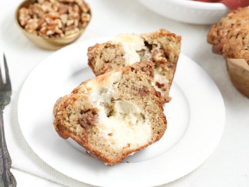 Banana bread coffee cake muffins with cream cheese filling and cinnamon swirl, cut open on a white plate