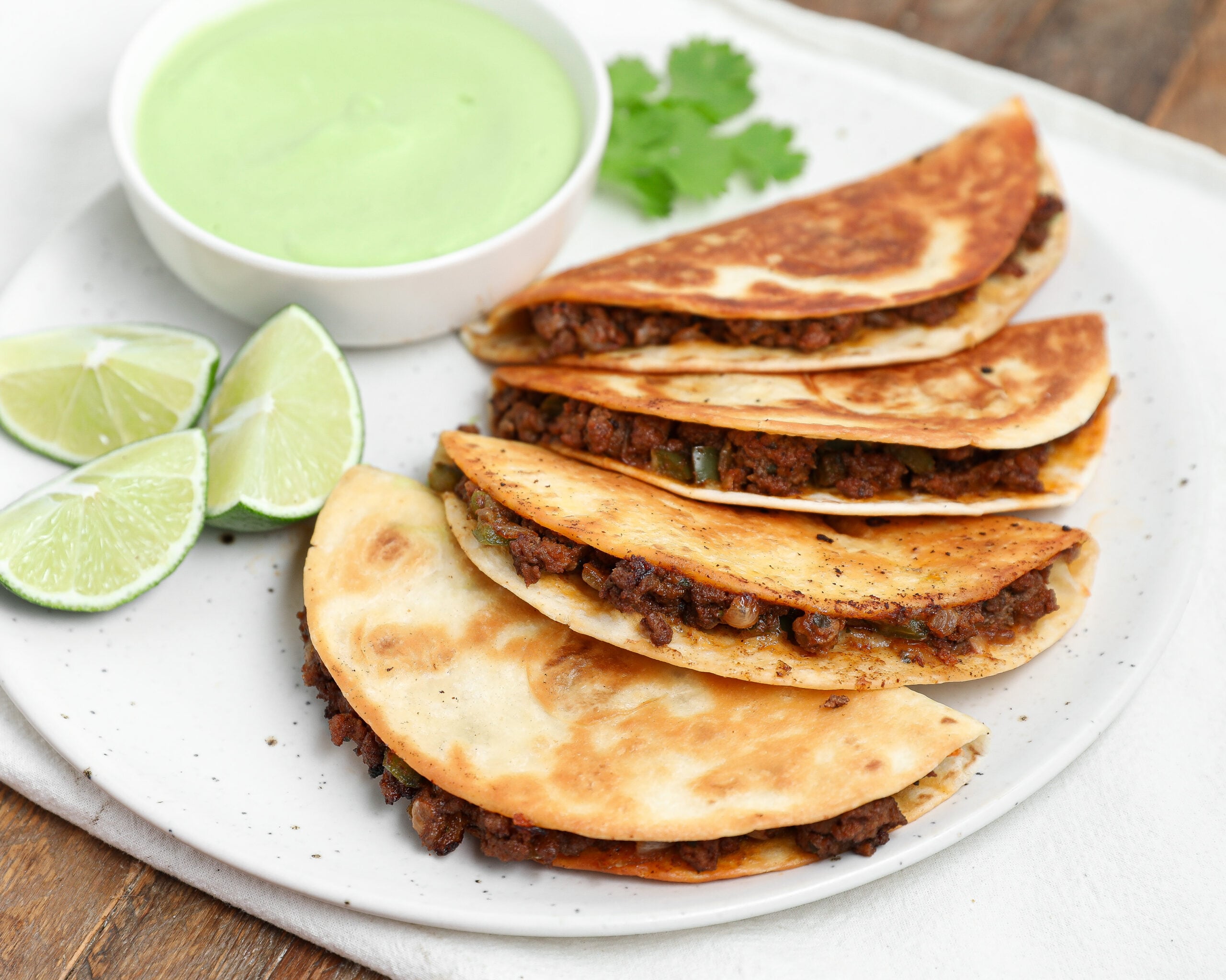 Plated Cheesy Crispy Beef Tacos with Avocado Cilantro Sauce