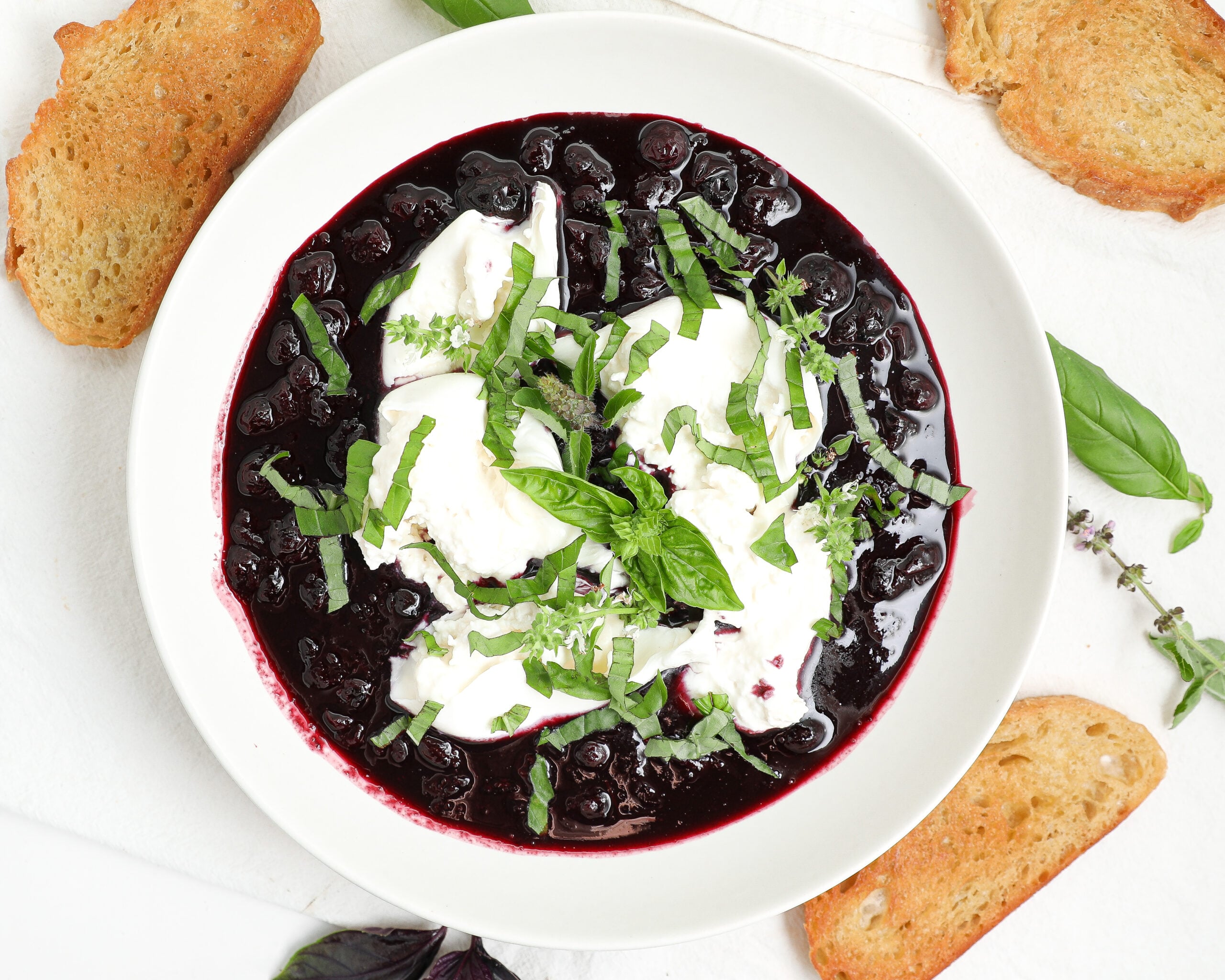 Blueberry burrata bruschetta with balsamic blueberries, basil, and toasted crostini.