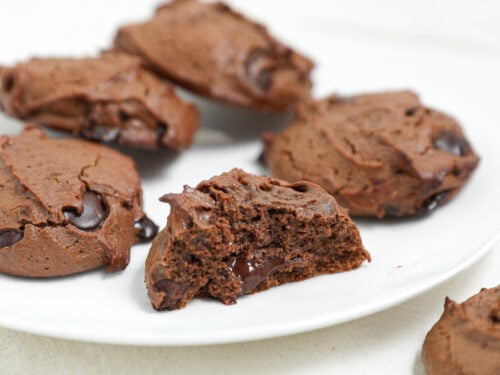 Fudgy protein brownie cookies with melted chocolate chips on a white plate