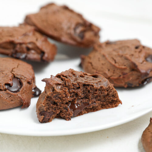 Fudgy protein brownie cookies with melted chocolate chips on a white plate