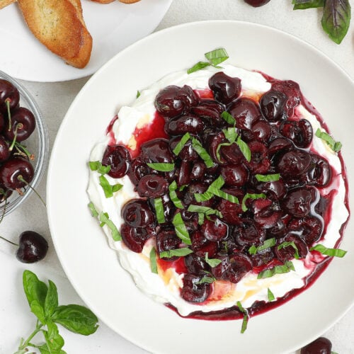 Creamy whipped feta dip topped with roasted cherries, fresh basil, and hot honey served with crostini.