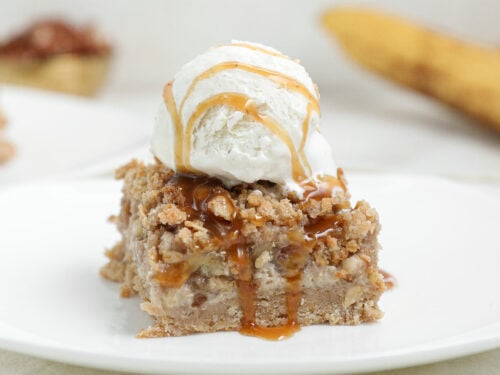 Banana Foster Cheesecake Crumble Bars with caramelized bananas, oat crumble topping, and caramel sauce.