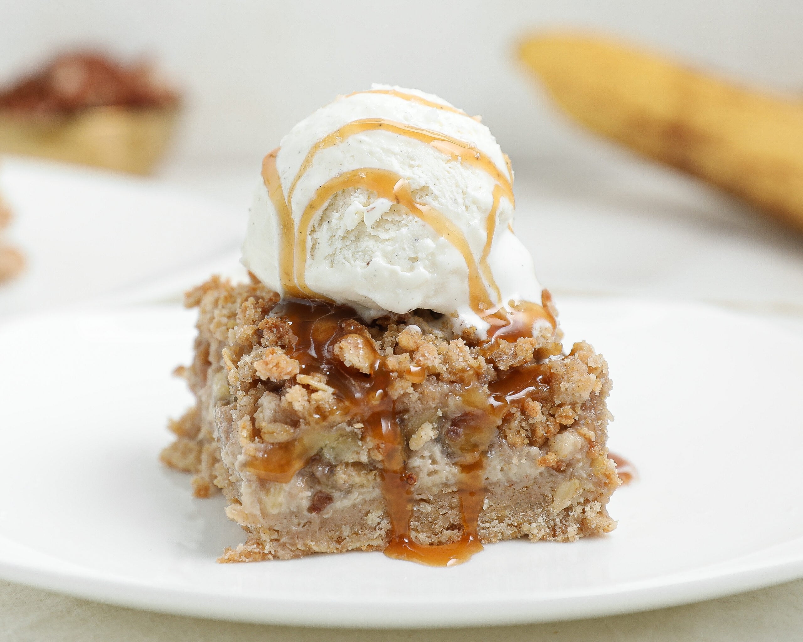 Banana Foster Cheesecake Crumble Bars with caramelized bananas, oat crumble topping, and caramel sauce.