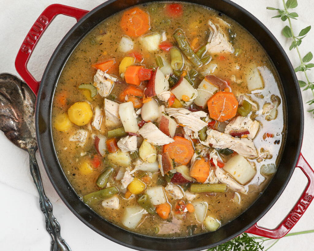 Easy chicken stew with tender chicken, potatoes, carrots, green beans, and kale in a flavorful broth
