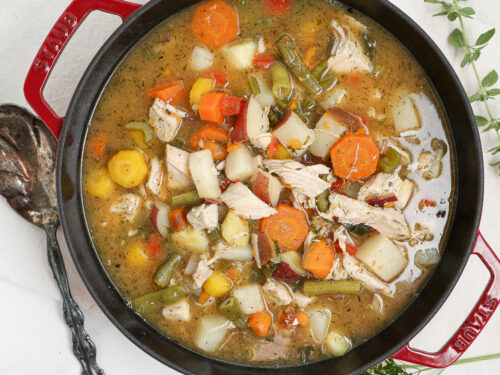 Easy chicken stew with tender chicken, potatoes, carrots, green beans, and kale in a flavorful broth