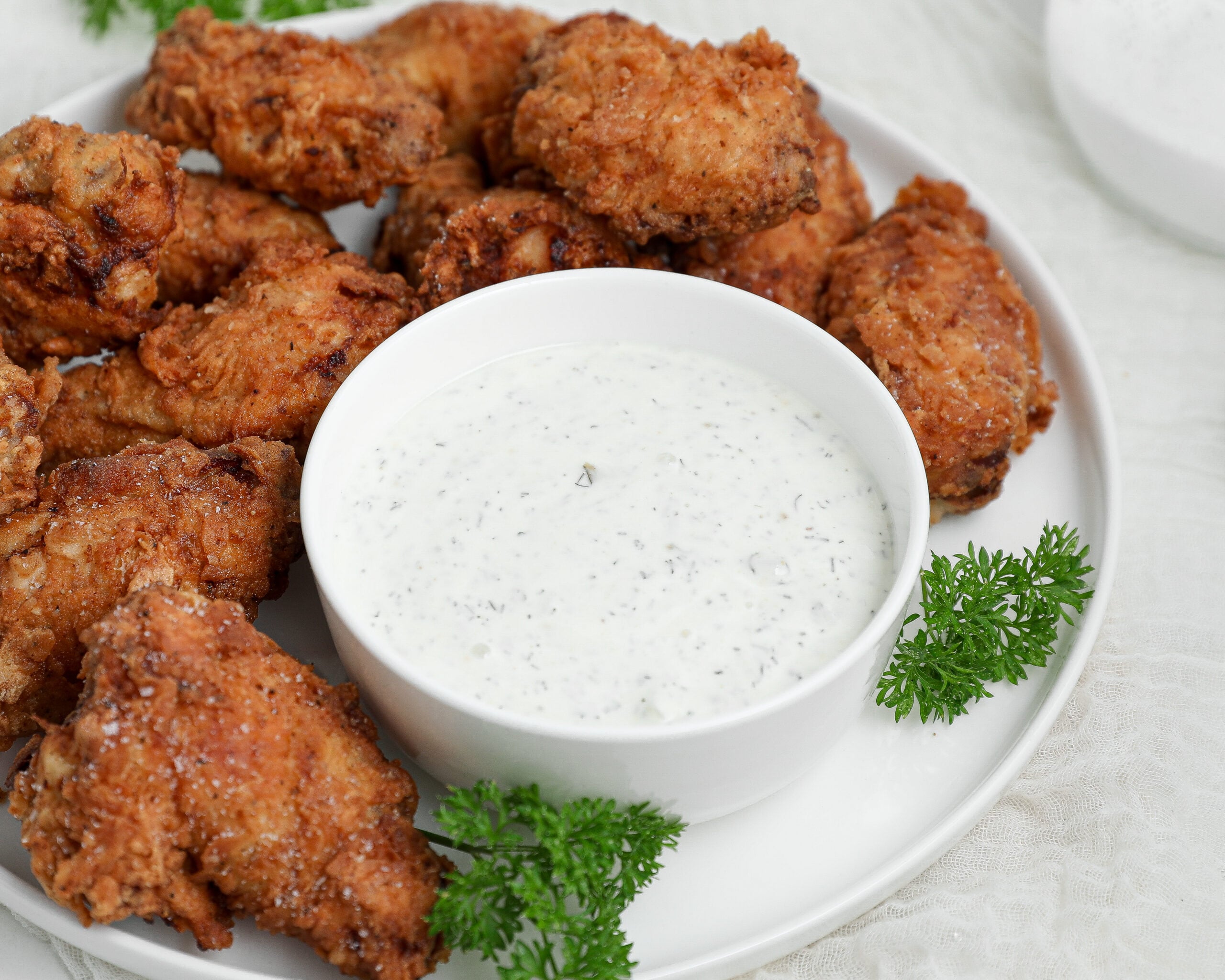 Small bowl filled with creamy homemade pickle ranch made with dill pickles and fresh herbs served as a dipping sauce.