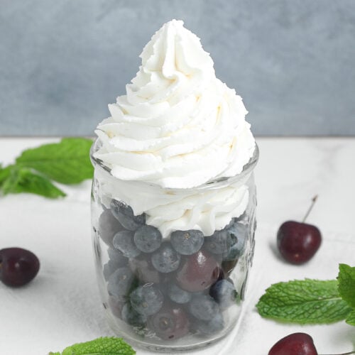 Homemade whipped cream in a glass bowl made with heavy cream, powdered sugar, and vanilla.