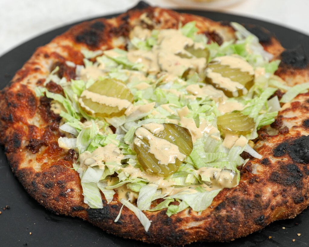Big Mac Pizza topped with homemade Big Mac sauce, shredded lettuce, dill pickles, and ground beef on a crispy homemade pizza crust.