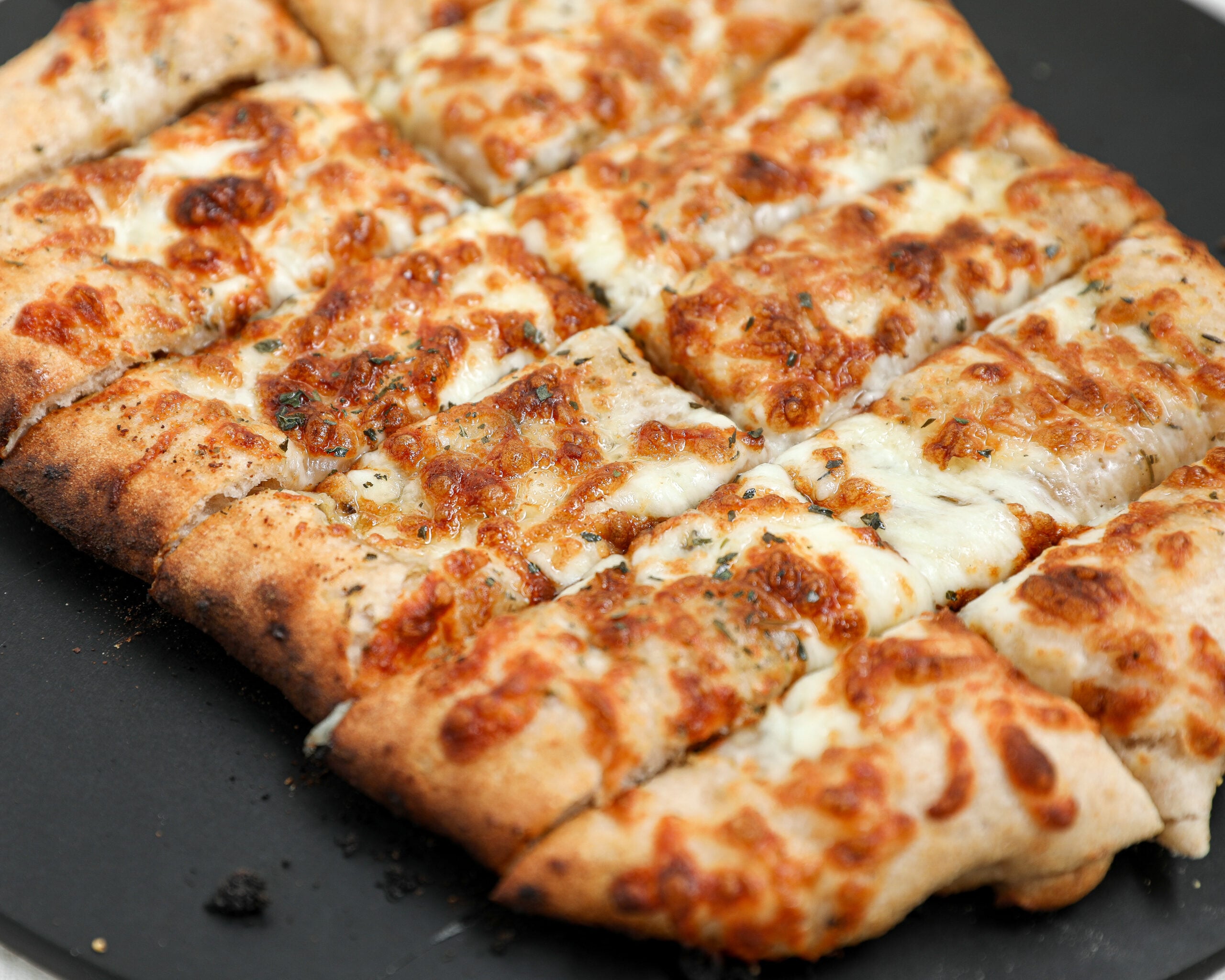 Cheesy Italian bread sticks made with sourdough pizza dough, garlic butter, and mozzarella cheese baked until golden brown and sliced into breadsticks.