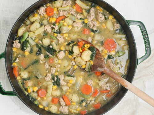 Creamy chicken gnocchi with tender chicken, potato gnocchi, carrots, corn, kale, and herbs in a creamy broth.