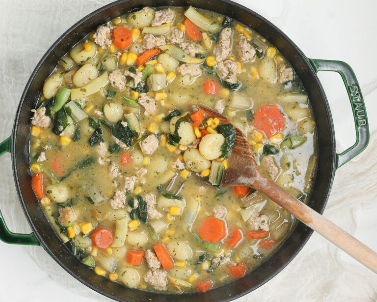 Creamy chicken gnocchi with tender chicken, potato gnocchi, carrots, corn, kale, and herbs in a creamy broth.