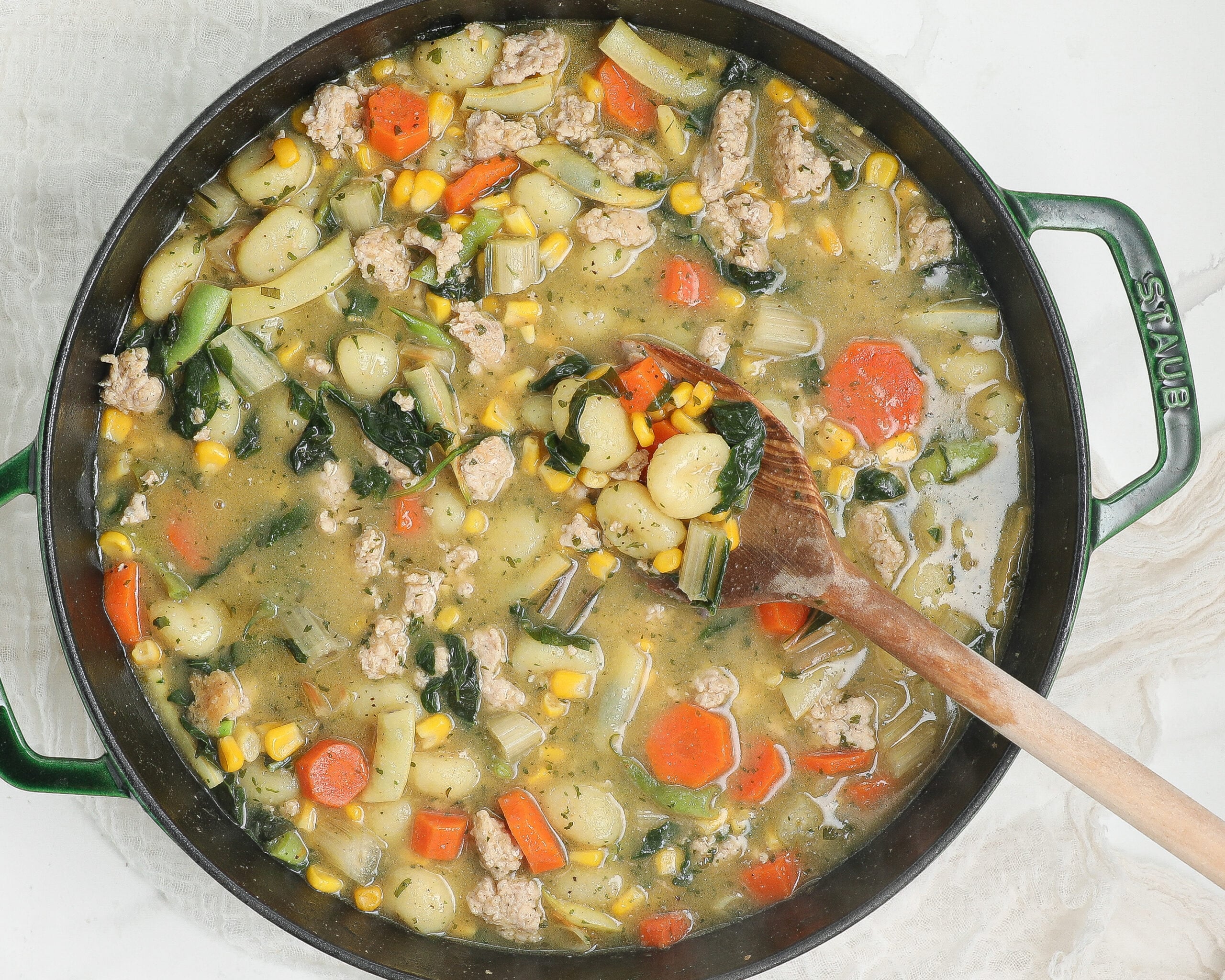 Creamy chicken gnocchi with tender chicken, potato gnocchi, carrots, corn, kale, and herbs in a creamy broth.