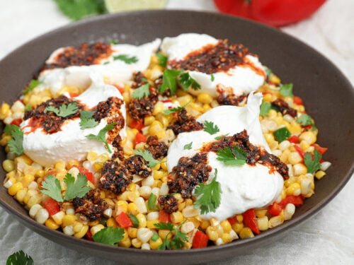 Warm Corn Burrata Dip with creamy burrata, sweet corn, peppers, crunchy garlic chili oil, fresh cilantro, and lime.