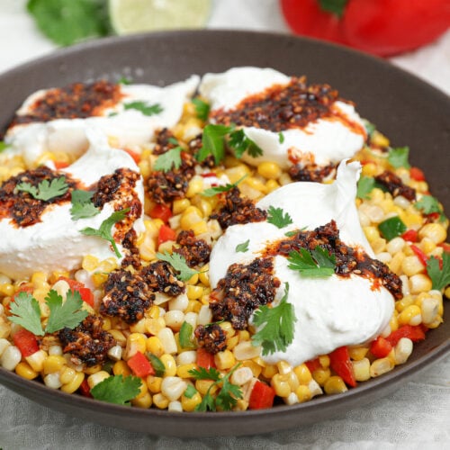 Warm Corn Burrata Dip with creamy burrata, sweet corn, peppers, crunchy garlic chili oil, fresh cilantro, and lime.