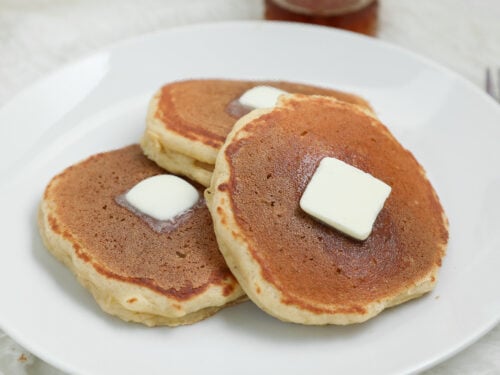 Banana Cottage Cheese Pancakes topped with melting butter on a white plate.