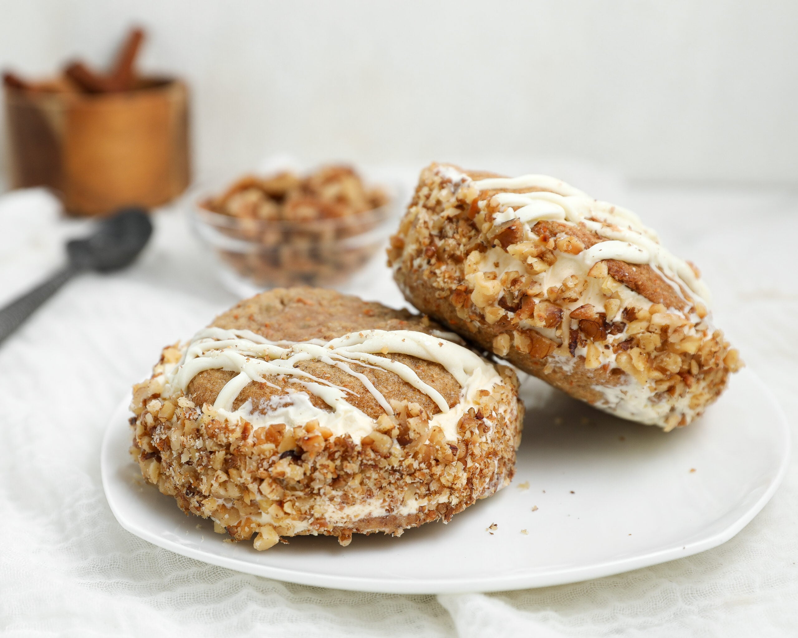 Carrot cake cookie ice cream sandwiches with cream cheese ice cream, toasted walnuts and white chocolate drizzle