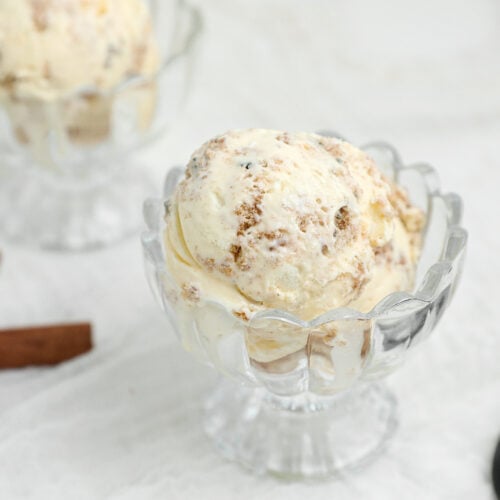 Carrot Cake Ice Cream with homemade carrot cake cookie pieces and creamy cream cheese ice cream served in a glass dessert dish.