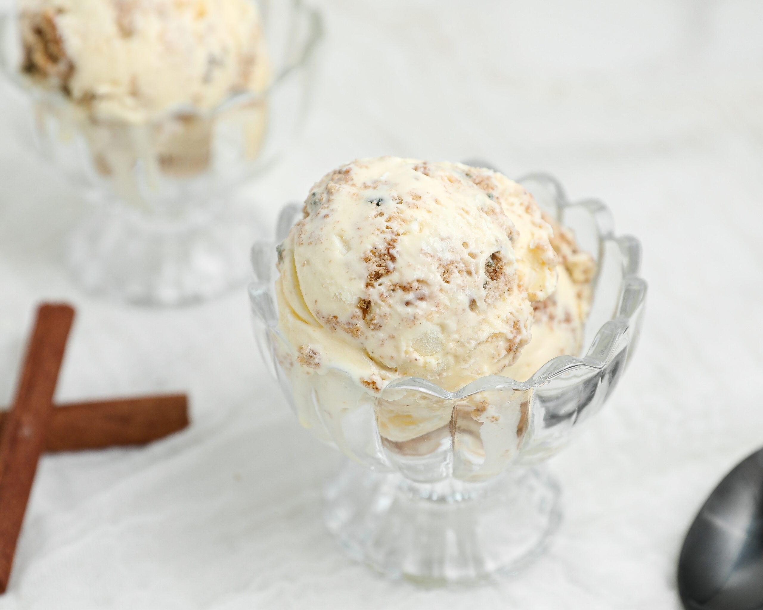 Carrot Cake Ice Cream with homemade carrot cake cookie pieces and creamy cream cheese ice cream served in a glass dessert dish.