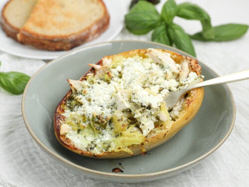 Chicken spaghetti squash with creamy pesto Alfredo sauce, shredded chicken, and Parmesan cheese.