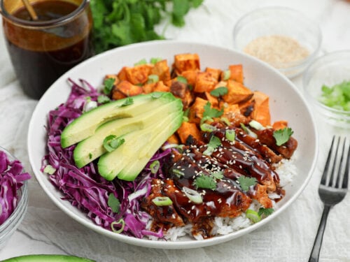 Korean BBQ Chicken Bowl with gochujang chicken, white rice, roasted sweet potatoes, shredded purple cabbage, avocado, and Korean BBQ sauce.