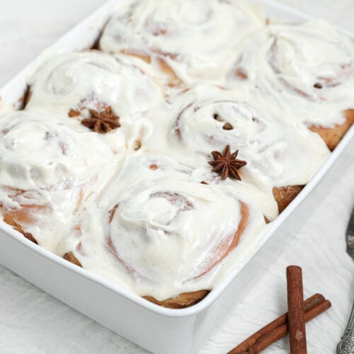 Chai cinnamon rolls with chai cream cheese frosting in a white baking dish