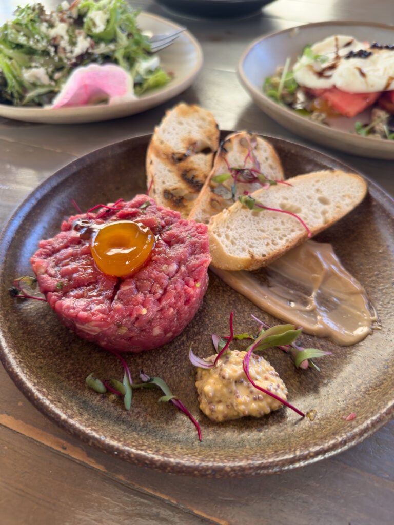 Steak tartare topped with an egg yolk and served with toasted bread at The Silo Cookhouse.